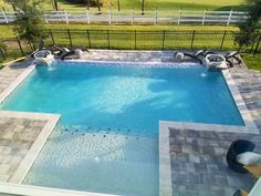 an above ground swimming pool surrounded by stone pavers and fenced in yard area