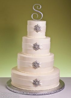 a three tiered wedding cake with snowflakes on top