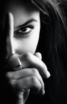 a woman making the middle finger sign with her hand in front of her face, black and white photo