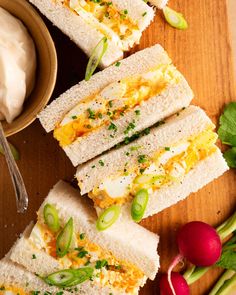 several sandwiches are stacked on top of each other next to radishes and sour cream