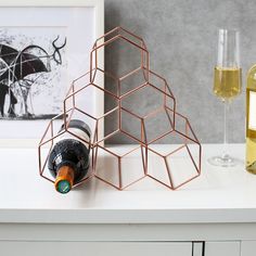 a bottle of wine sitting on top of a white counter next to a glass filled with wine