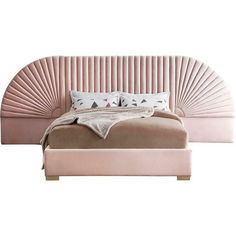 a bed that is made up with pink sheets and pillows on top of the headboard