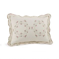 a white pillow with pink flowers on the front and back, sitting on a white surface