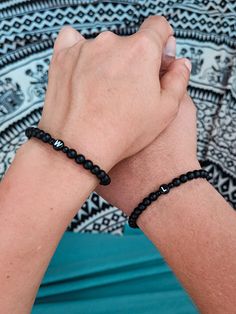 a person wearing a black beaded bracelet