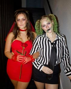 two women dressed up in costumes and makeup posing for the camera with one holding a rose