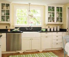 a clean kitchen with white cabinets and black counter tops is seen in this image from the dining room