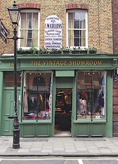 the vintage showroom is located in an old brick building with green shutters and windows