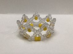 a yellow and white beaded bracelet on a white surface