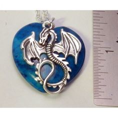 Dragon and Light Blue Riverstone Heart Necklace A soaring winged silvertone dragon and Light blue Riverstone heart stone. In modern times dragons have remained an important part of our culture. Dragons represent luck, power and strength A blue heart can be used to express love, support, admiration, happiness, and excitement create a “Dragon Love” necklace. A unique way to wear and display your dragon. * A dyed quartz gemstone pendant * 1.25 inch (3.5 cm) silver tone dragon * 1.25 inches x 1.25 i Valentine's Day Themed Heart Jewelry, Valentine's Day Heart Shaped Themed Jewelry, Valentine's Day Heart-shaped Themed Jewelry, Blue Fantasy Jewelry For Gifts, Blue Fantasy Jewelry For Gift, Themed Heart-shaped Jewelry Gift, Handmade Blue Fantasy Jewelry, Personalized Themed Blue Jewelry, Unique Blue Jewelry For Valentine's Day