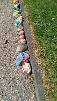 a row of painted shoes sitting on the side of a road next to a curb