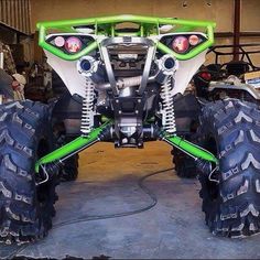 the front end of a green and white four wheeler