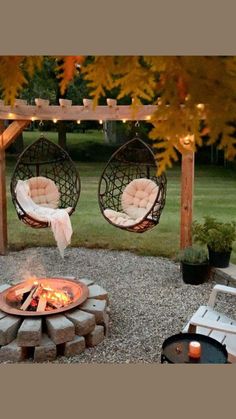 an outdoor fire pit with two hanging chairs