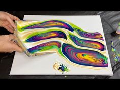 someone is painting an art piece with acrylic paint on paper and then using glue