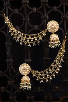 A traditional masterpiece, replete with traditional grandeur and an opulent design, these earrings are richly encrusted kundan jhumkas. The long hair chain with dangling trinkets of pearl suffuses the design with charm. Closure - Push-Back Style Tip - When it comes to getting a classic look, nothing can be better than pearls and kundan. This necklace set is fit for a woman who is fiercely independent yet rooted in traditional and cultural heritage, carving her own style with classic and timeless Jhumkas With Hair Chain, Jhumka With Ear Chain Hairstyle, Kundan Jhumkas, Fiercely Independent, Indian Wedding Jewelry Sets, Hair Chain, Inexpensive Jewelry, Ear Chain, Hair Chains