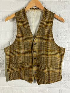 Vintage 1960's Glen Plaid Wool Blend Vest Waist Coat. Men's medium. Brown and Gold Plaid Wool Front with Olive Green Nylon Back and Ivory Inner Lining. In Good Vintage Condition with some Fading on the outer Back Shell and some discoloration on the inner shell. All due to age and sunlight. Vest has two lined pockets on the front. If you have any questions, please don't hesitate to ask!  Thank You Tailored Vintage Cotton Outerwear, Tailored Vintage Winter Vest, Tailored Vintage Fall Vest, Vintage Winter Vest With Button Closure, Vintage Fitted Vest For Fall, Vintage Fall Vest With Buttons, Vintage Beige Vest With Pockets, Beige Vintage Vest With Pockets, Tailored Vintage Wool Vest