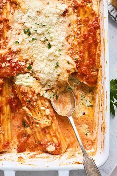 a casserole dish filled with pasta and sauce, topped with parmesan cheese