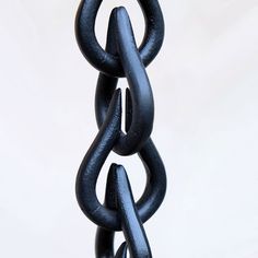 a black metal object is hanging from a chain