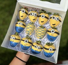 a box filled with minion cupcakes in the shape of pineapples