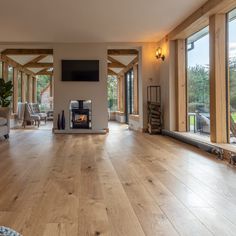 a large open living room with wood floors and lots of windows on both sides of the room