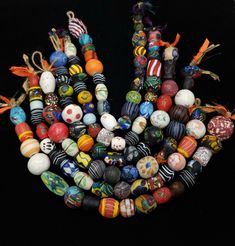 a bunch of different colored beads on a black background