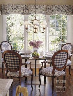 a dining room table with four chairs and a chandelier hanging from the ceiling