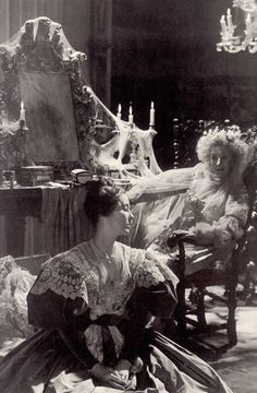 an old black and white photo of two women sitting in chairs with candles on them