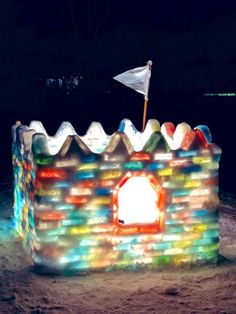 an inflatable castle with a flag on top is lit up for the night