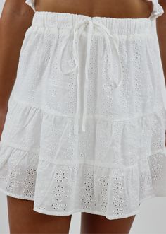 This flowy skirt is perfect for any occasion! Wear it to the beach with your friends or to a fun brunch. It features a white eyelet lace detail and an adjustable drawstring in the front. Model Info Meet Courtney! Here she is wearing a size small. Hips: 35” | Waist: 26” | Bust: 32” | Height: 5’0” space The Details Eyelet Lace Adjustable Drawstring Detail Hand Wash Cold Separately, Lay Flat To Dry 100% Rayon Nantucket Outfit, I Like Me Better, Small Hips, White Skirt Outfits, Cute White Tops, Eyelet Skirt, Drawstring Detail, Preppy Girl, Lace Outfit