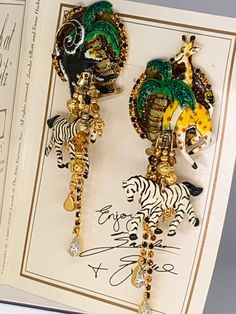 "Lunch at the Ritz Statement Monkey, Giraffe, and Zebras  Dangle Earrings  4.5\" Long  1.5\" Wide  A great statement pair of earrings, don't wait to add them to your collection.  They are highly collectible and usually hard to find and sell quickly.  Lunch At The Ritz jewelry is made In the beautiful Hudson River Valley, of New York, USA.  All jewelry is made with 14kt gold post or clips, Austrian Crystal, and Czechoslovakian Glass, and is topped with a thick coating of 24kt gold or Palladium si Bold Statement Jewelry, Hudson River Valley, Body Adornment, The Ritz, Hudson River, River Valley, 24kt Gold, Polymer Clay Crafts, Austrian Crystal