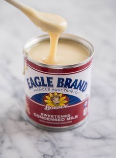 an open can of eagle brand spread with a wooden spoon