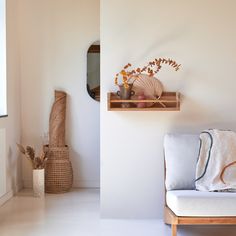 a white couch sitting next to a wooden shelf filled with vases and other items