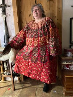 This caftan is made of screen printed India cotton fabric in bright red with multi colored design. It is one size fits most just like the good old Medieval days.  Shaping is accomplished with a belt.  Photo #6 is the same size and pattern (different fabric) on a med woman, belted with Kurdish pants.  Photo #1 is the exact same tunic on a size 3 XLarge.  Photo 2 is the same tunic on an XL man. Measurements: chest measurement is 64 inches  sleeve end, across shoulders to opposite sleeve end 70 inches  length from shoulder to hem is 48 inches   Preshrunk from the makers there is a slight bit of residual shrinkage.  Machine wash and dry - or just get rained on, it dries quickly! I have been wearing these for years as my night wear.  Very durable and easy care.  I use them at camping events lik Red Floral Print Tunic Kaftan, Traditional Red Floral Print Kaftan, Red Bohemian Cotton Kaftan, Red Cotton Bohemian Kaftan, Red Floral Print Kaftan For Festival, Red Bohemian Kaftan With Traditional Patterns, Traditional Red Kaftan With Floral Print, Red Tunic Kaftan For Festivals, Red Long Cotton Kaftan