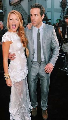 a man and woman standing next to each other on a black carpet at an event