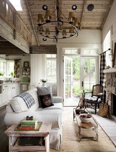 a living room filled with furniture and a chandelier hanging over the top of it