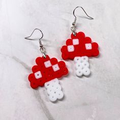 Custom-made Perler Bead earrings. Each earring features silver earring hooks, ensuring they are nickel-free for sensitive ears. These earrings are not only lightweight but also add a playful touch to any outfit, making them a joy to wear. Approximate size 1.5"  DISCLAIMER: perler beads melt differently each time and will vary from product photos White Earrings With Mushroom Design As Gift, White Mushroom Design Earrings For Gift, White Mushroom Design Earrings As Gift, White Dangle Earrings With Mushroom Design, White Mushroom Design Drop Earrings, Perler Bead Earrings, Mushroom Earrings, Outfit Making, Perler Bead