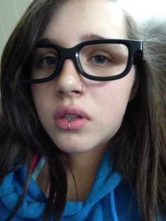 a woman with glasses on her face and tongue sticking out