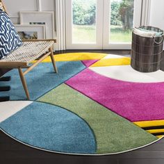 a brightly colored rug in the middle of a living room with a chair and window