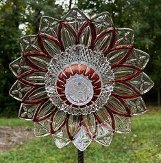 a glass sunflower on a stand in the grass