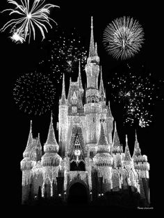 a black and white photo of a castle with fireworks