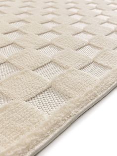 a close up view of a white rug with squares on it