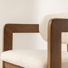 a wooden chair with white upholstered cushions