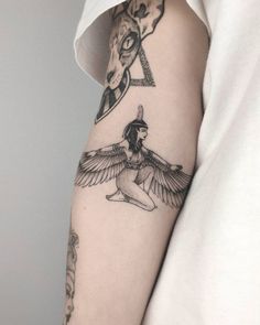 a woman's arm with tattoos on it and an animal head in the background