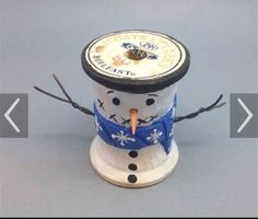 a snowman made out of some kind of tin can with a carrot sticking out of it