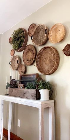 several baskets are hanging on the wall above a table