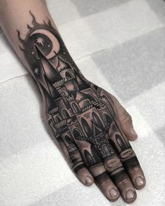 a hand with a castle tattoo on it