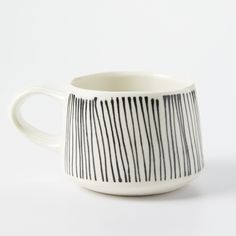 a white and black coffee cup with lines on it