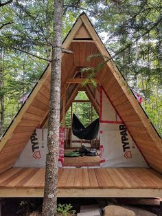 a tent in the woods with a hammock inside