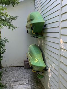 two green boats mounted to the side of a house