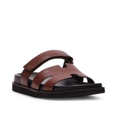 Steve Madden-Maiven Sandal The Steve Madden Maiven sandal is all about style and practicality. A front strap with geometric cutouts brings flair to the leather sandal. An adjustable top hook-and-loop strap ensures a snug fit. With a molded footbed and treaded flatform sole, city strolls are sure to be comfortable. Modern Open Toe Sandals, Leather Sandals With Strap Detailing For Spring, Spring Leather Sandals With Strap Detailing, Modern Leather Slides With Double Strap, Modern Leather Double Strap Slides, Modern Double Strap Leather Slides, Modern Brown Sandals With Buckle Closure, Modern T-strap Sandals With Heel Loop, Modern Leather Open Toe Sandals