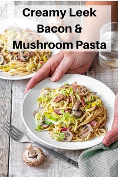 two plates of creamy leek bacon and mushroom pasta on a wooden table with mushrooms